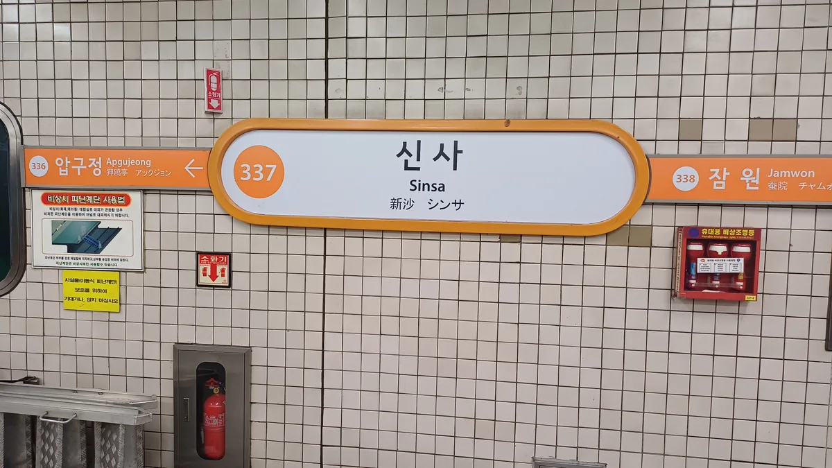 Orange Line 3 station sign reading 337 Sinsa in Korean and English on a tiled platform wall.
